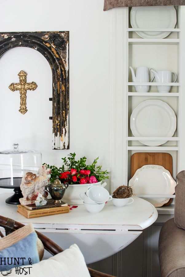Kitchen cubbies get a makeover into a built in plate rack filled with gorgeous goodies like white and wood. White plates, cutting boards and antique tea and coffe pots. This simple DIY will help you transform small shelves into functional display space.
