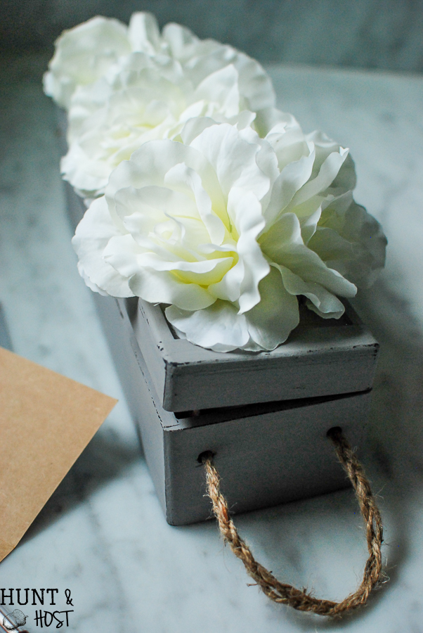 An old wine gift box transformed into a blooming storage box with dollar store flowers. PLUS five other DIY dollar store ideas with flowers.