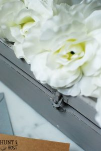 An old wine gift box transformed into a blooming storage box with dollar store flowers. PLUS five other DIY dollar store ideas with flowers.