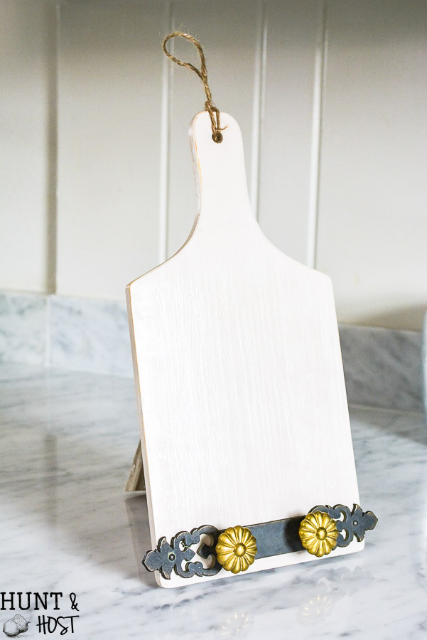 Dollar store decorating hacks for you to get your home decor on a dime! This dollar store DIY turns a wood cutting board into a tablet stand for recipe time in the kitchen.