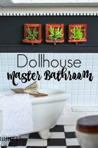 Dollhouse master bathroom decor ideas for a farmhouse bathroom. This tiny bathroom has it all, a claw tub, farmhouse sink, black and white checkered floor and cute DIY wall art.