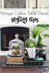 Adding vintage items to your coffee table décor is the perfect way to add age and interest to your living room. WIth these coffee table styling tips you will have your tabletop vignette rocking a vintage vibe in no time! #vintagestyle #frenchcountrycottage #frenchcountryliving #tarnishedsilver #succulentlove #clochedecor