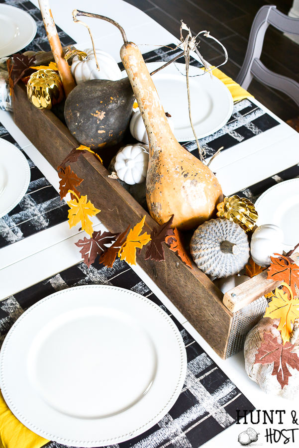 A simple fall table setting with buffalo plaid accents via chalkboard placemats. Layer on the metallic ad gold hues that are popular fall colors this year! CHeck out an entire array of simple fall décor inspiration from mantels to free printables, this post has it all! #chalkboard #meatllics #falltable #gourds #simplefall