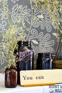 Decorating the mantel for fall with amber glass jars and roadside dreid flowers.