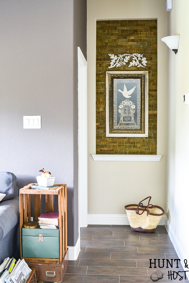 Taking your boring art niche up a notch with this quick afternoon makeover. How to install peel and stick wood tiles to decorate a small space with rustic style. #woodtile #artniche #rusticdecor #woodwall #easyshiplap