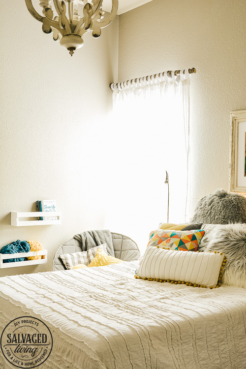 Design a cozy reading corner in your bedroom for a soft and dreamy retreat perfect for getting lost in a good book! Simple touches set the mood for this reading nook! #bookworm #readingnook #readingcorner #bedroomretreat #booknook #cozyreadingcornerforteens #DIYcurtains #bookshelf #cratefurniture