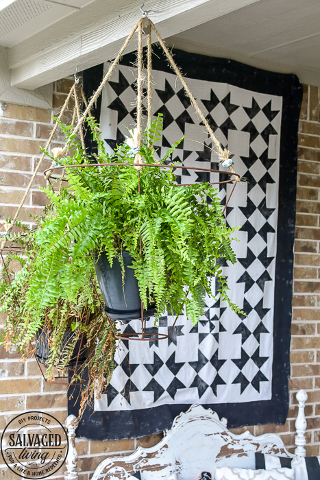 Looking for an unusual outdoor hanging basket for your favorite patio plants? This vintage lampshade makes the perfect hanging basket and is a simple upcycle for your porch. #outdoorhangingbasket #industrialvintageporch #lampshadeideas #DIYplanthanger #diyhangingbasket #outdoorpatiodecor #fern #vintageporch