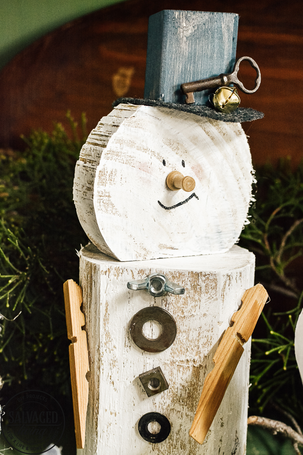 Learn how to make a cheap and easy DIY scrap wood snowmen family. The perfect Christmas decoration or gift idea for a family. This easy snowman craft lets you personalize each snowman face and outfit with junk art from your house! #holidaydecor #handandeChristmas ##snowmancrafts #woodensnowmen #farmhouseChristmas