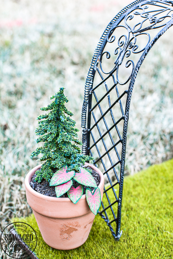 Tour a miniature vintage garden shop dollhouse for great ideas for your own dollhouse decor. See how to make a cozy home, lush garden and outdoor miniature yard! COmplete with garden gnomes, miniature potted plants and sitting areas. #dollhouse #miniatures #DIYdollhouse #vintagegarden #tinydecor