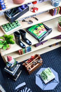 Tour a miniature vintage garden shop dollhouse for great ideas for your own dollhouse decor. See how to make a cozy home, lush garden and outdoor miniature yard! COmplete with garden gnomes, miniature potted plants and sitting areas. #dollhouse #miniatures #DIYdollhouse #vintagegarden #tinydecor