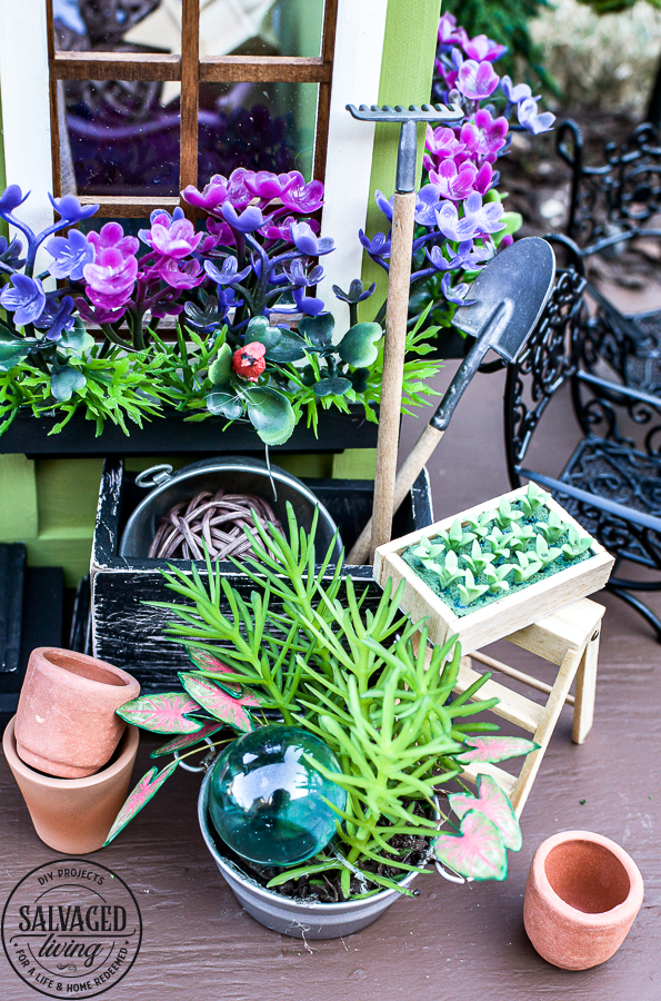 Tour a miniature vintage garden shop dollhouse for great ideas for your own dollhouse decor. See how to make a cozy home, lush garden and outdoor miniature yard! COmplete with garden gnomes, miniature potted plants and sitting areas. #dollhouse #miniatures #DIYdollhouse #vintagegarden #tinydecor