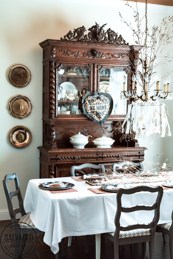 Create a romantic table for Valentine's Day on a tight budget with tons of dollar store crafts mixed with vintage items to bring together a romantic picnic...inside! Bringing the outdoors is always a stylish budget friendly option for holiday decorating! #valentinesdaydecorations #valentinesdaycrafts ##valentinesdaydollarstore #romantictable #farmhousevalentinesday