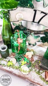 St. Patrick's Day decor ideas from the Dollar store. Use this cute St. Patrick's day wreath tutorial and St. Patrick's Day home decor styling idea to create a cute green space in your home! Mix old, vintage items with dollar store decor for a classic St. Paddy's day look. #stpatricksday #dollarstorecraft #budgetdecoridea