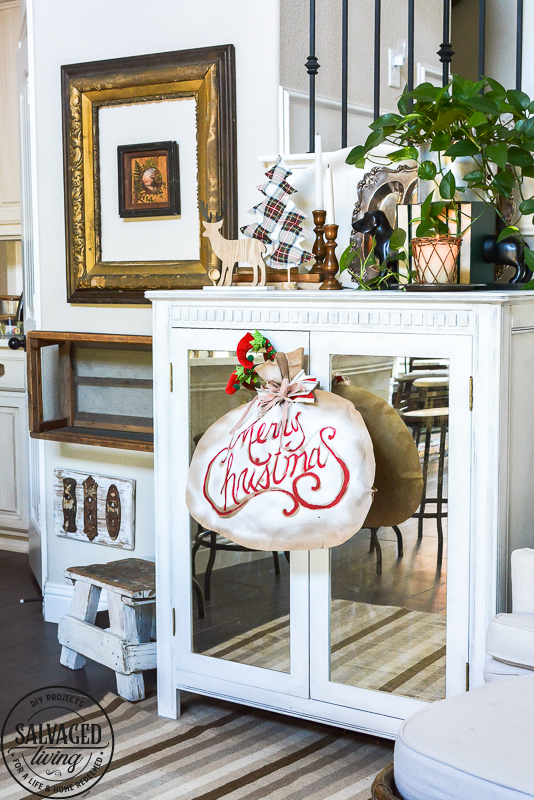 Make a quick and easy dollar store Christmas craft with cute little elf legs and a DIY Santa sack for a festive wall hanging. DIY Christmas decor idea that is cute and easy to make. #elfdecor #dollarstoreDIY #christmascraft #dollartreeDIY #stencilidea