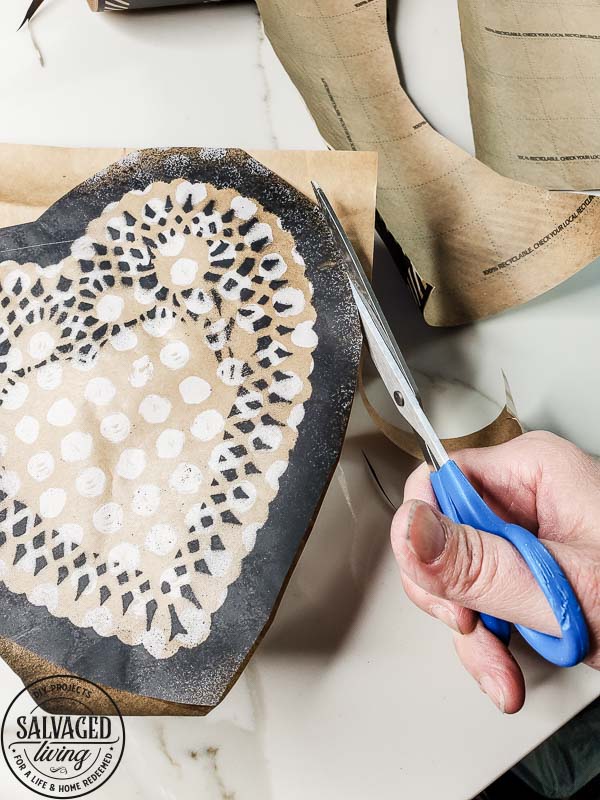 Learn how to make gorgeous giant paper hearts for Valentine's Day decorating on repurposed spindle stands. This dollar store craft is perfect for a farmhouse Valentine theme. #vintageValentine #upcycledprojectidea #spindle #papercraft #stencilart #valentinesdaymantel