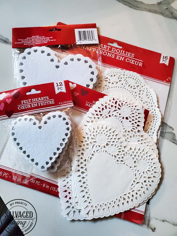 Learn how to make gorgeous giant paper hearts for Valentine's Day decorating on repurposed spindle stands. This dollar store craft is perfect for a farmhouse Valentine theme. #vintageValentine #upcycledprojectidea #spindle #papercraft #stencilart #valentinesdaymantel