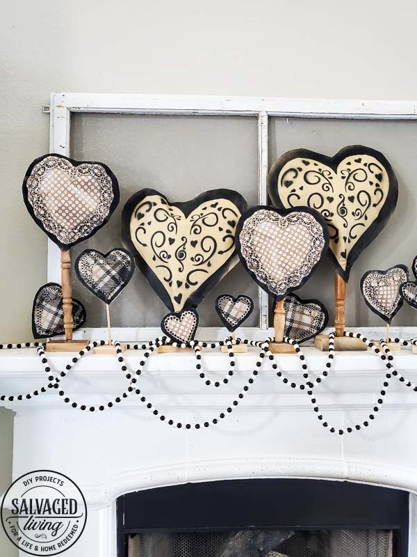 Learn how to make gorgeous giant paper hearts for Valentine's Day decorating on repurposed spindle stands. This dollar store craft is perfect for a farmhouse Valentine theme. #vintageValentine #upcycledprojectidea #spindle #papercraft #stencilart #valentinesdaymantel