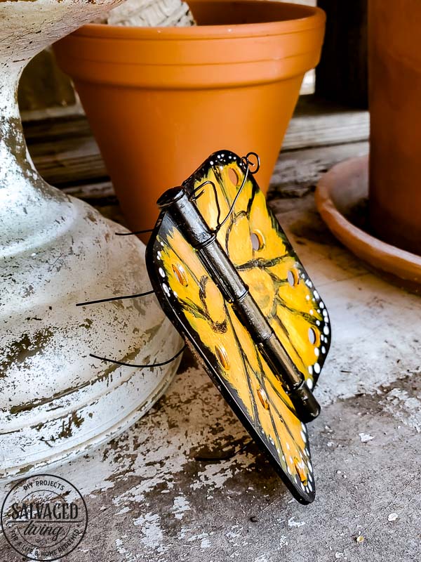 Wonder what to do with old door hinges? Try this upcycled door hinge butterfly project for a fun and beautiful addition to your spring decor ideas. These painted butterflies are perfect for your patio and potted plants. Truly adorable yard art you can DIY with thrifted or left over materials! #butterflyart #doorhinge #upcycledcraft #springdecor #springcraft