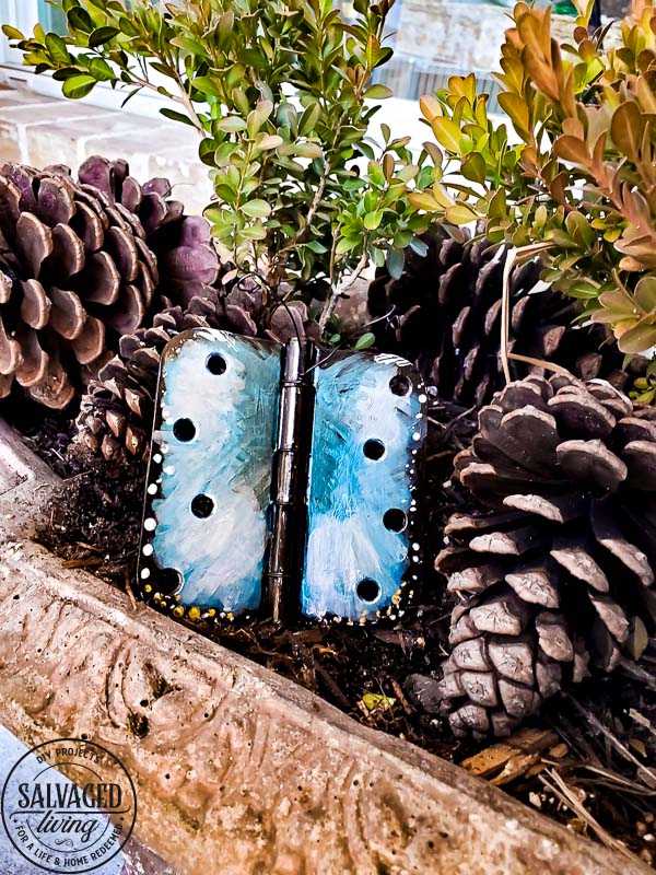 Wonder what to do with old door hinges? Try this upcycled door hinge butterfly project for a fun and beautiful addition to your spring decor ideas. These painted butterflies are perfect for your patio and potted plants. Truly adorable yard art you can DIY with thrifted or left over materials! #butterflyart #doorhinge #upcycledcraft #springdecor #springcraft