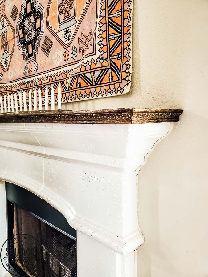 See how to make a stone fireplace mantel into a wood fireplace mantel. This DIY mantel idea is perfect for the person who loves to decorate their mantel but struggles with how to hang deocr on stone mantel or concrete mantel. It is an easy fireplace fix for a more functional fireplace mantel. #woodmantel #DIYmantel #manteldecor #stonefireplaceidea 