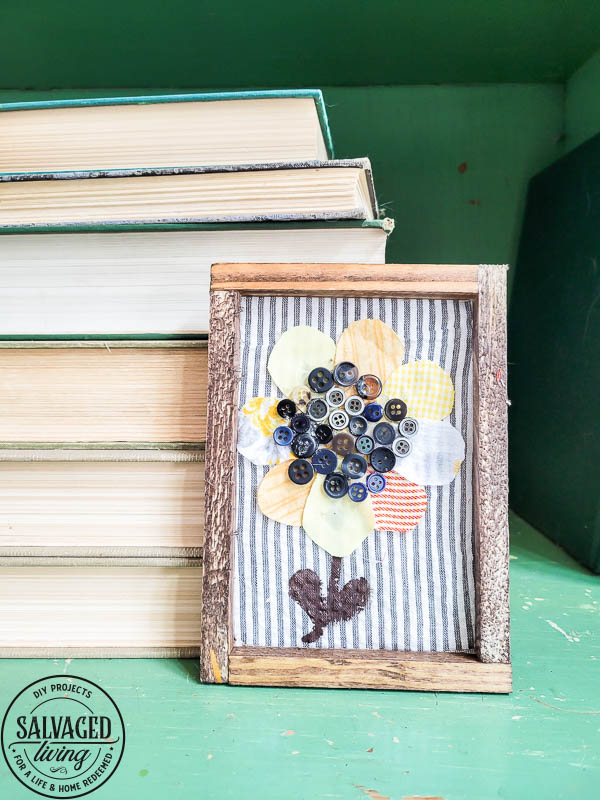 finished sunflower art in frame on table with books