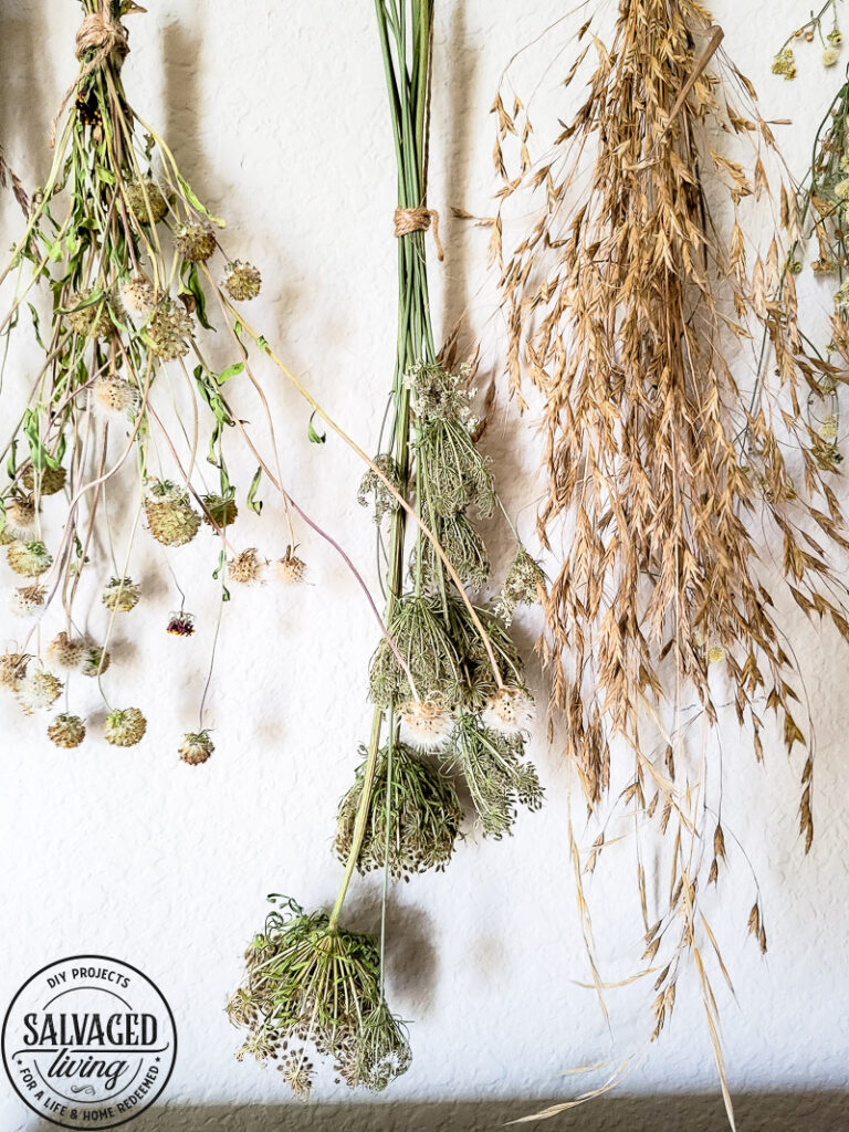 Make a stunning wall hanging from dried flowers and dried grasses for you a boho chic wall hanging in your home. This simple DIY is budget-friendly decor at it's finest! #wallart #driedflowers #bohodecor #farmhousewallart 