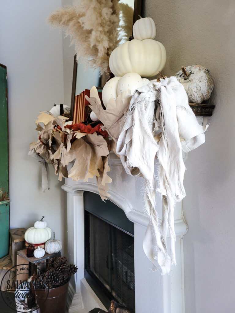 Learn how to make DIY giant paper leaf garland for your fall mantel or fall decorating. This budget garland idea is perfect to add a warm touch of fall to your home and the tutorial is so easy! Mix in some white pumpkin decor, gathered ribbon garland and cozy books for a cozy fall decor idea! #fallvibe #papergarland #papercraft 