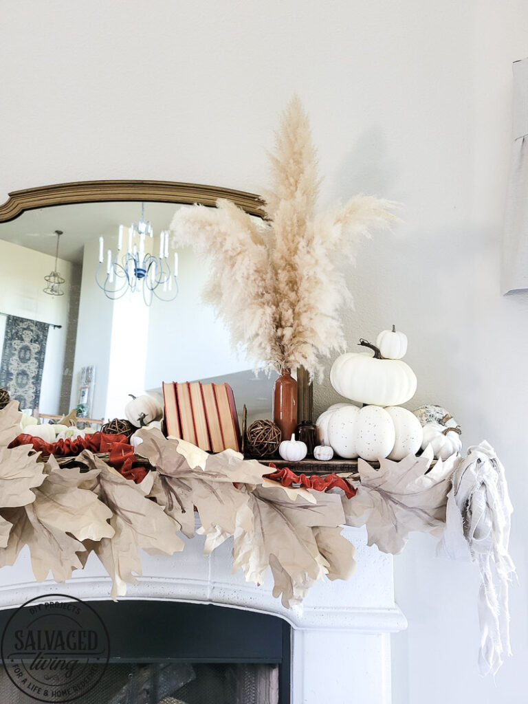 Learn how to make DIY giant paper leaf garland for your fall mantel or fall decorating. This budget garland idea is perfect to add a warm touch of fall to your home and the tutorial is so easy! Mix in some white pumpkin decor, gathered ribbon garland and cozy books for a cozy fall decor idea! #fallvibe #papergarland #papercraft 