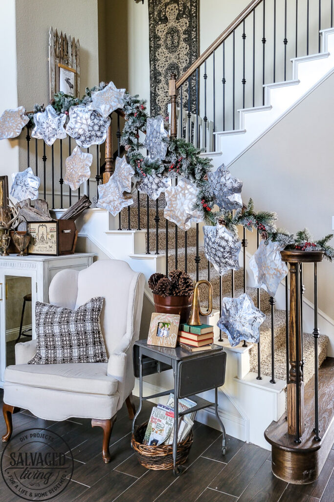 This simple DIY snowflake garland from dollar store felt pieces and Rust-Oleum Imagine spray paint is the perfect winter wonderland addition. Bring a flurry of snow to your holiday home decor with a papercraft for any decor style. The perfect DIY staircase decorating idea for your holiday banister! #rustoleum #rustoleumimagine #snowflake #winterwonderland #holidaydecor #holidaydecorating #christmasdecor #sponsored #staircasedecor 