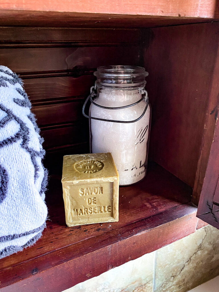 a thrifted cabinet found at a garages sale is perfect for a cozy bathroom upgrade, come see how I decorated this garage sale cabinet for function and style. #bathroomdecor #vintagebathroomstyle #cozybathroom