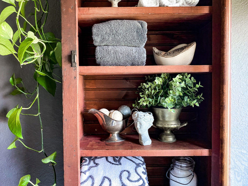 a thrifted cabinet found at a garages sale is perfect for a cozy bathroom upgrade, come see how I decorated this garage sale cabinet for function and style. #bathroomdecor #vintagebathroomstyle #cozybathroom