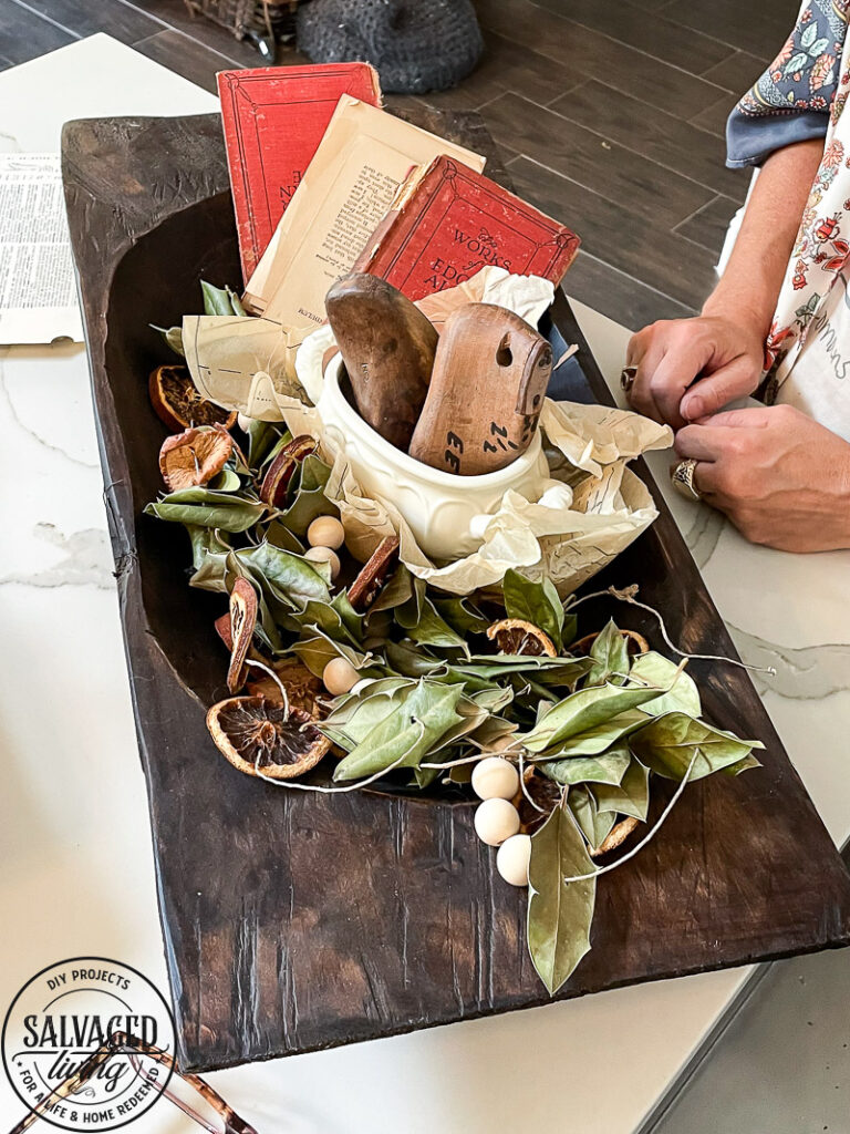 how to decorate a dough bowl with nature and vintage items. Here are 19 ways to decorate your dough bowl for a rustic vintage farmhouse style. These versatile decorating ideas are sure to give you lots of dough bowl inspiration. #doughbowldecor #vignetteideas #smallspacedecor #vintagedecor #cozyhome