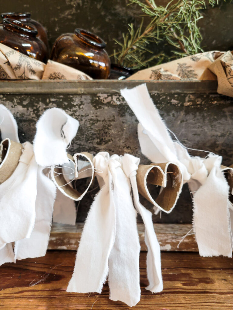 Instead of throwing away your old toilet paper and paper towel rolls, we can turn them into a beautiful farmhouse garland you will use for years to come! #farmhouse #papertoweltube #garland