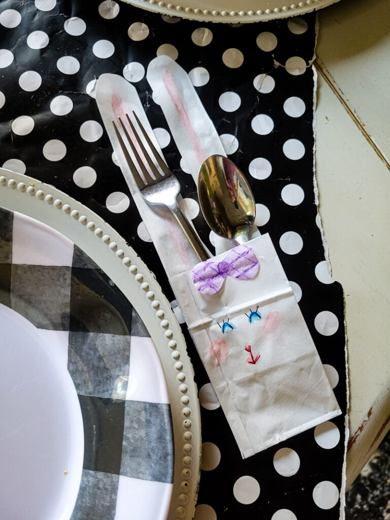 Use a lunch sack to create the cutest DIY utensil holders for Easter! This is the perfect craft to do with your kids, and use them all season before trashing them-- guilt free! #kidcraft #easterdiy #easyeastercraft