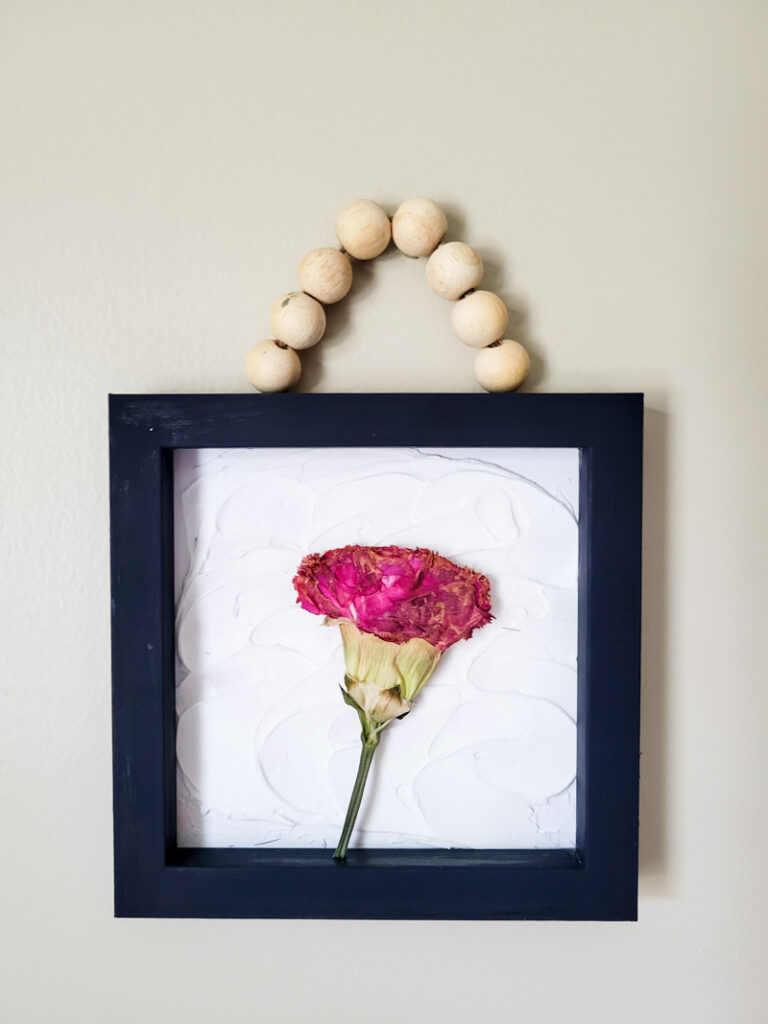 how to create dried flower wall art for budget-friendly decor that is feminine and sweet. This cozy vintage dorm room is a beautiful home away from home. Dried grocery store flowers came in handy to create this boho chic room decor! #dormdecor #driedflowers #DIYwallart