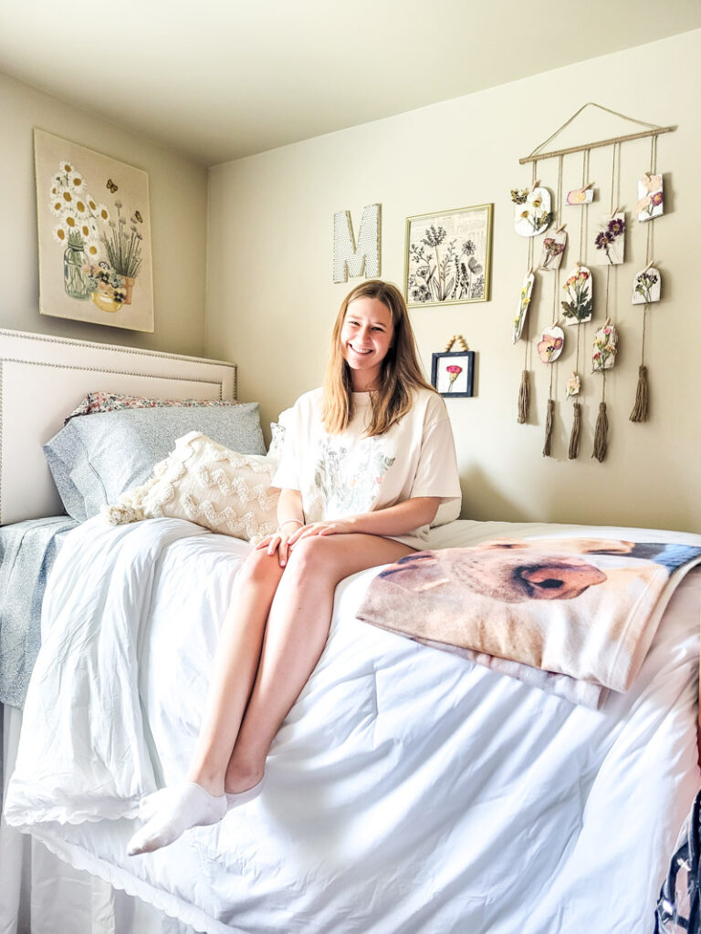 how to create dried flower wall art for budget-friendly decor that is feminine and sweet. This cozy vintage dorm room is a beautiful home away from home. Dried grocery store flowers came in handy to create this boho chic room decor! #dormdecor #driedflowers #DIYwallart