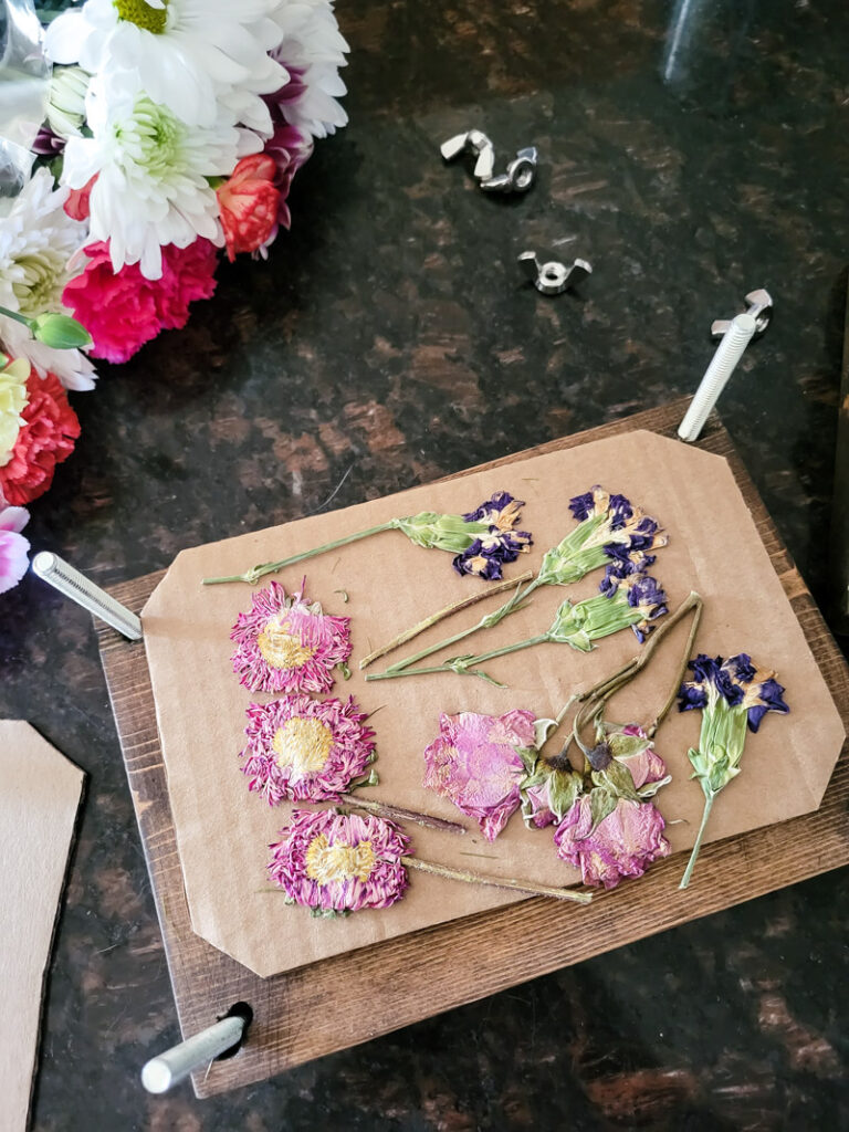 how to create dried flower wall art for budget-friendly decor that is feminine and sweet. This cozy vintage dorm room is a beautiful home away from home. Dried grocery store flowers came in handy to create this boho chic room decor! #dormdecor #driedflowers #DIYwallart