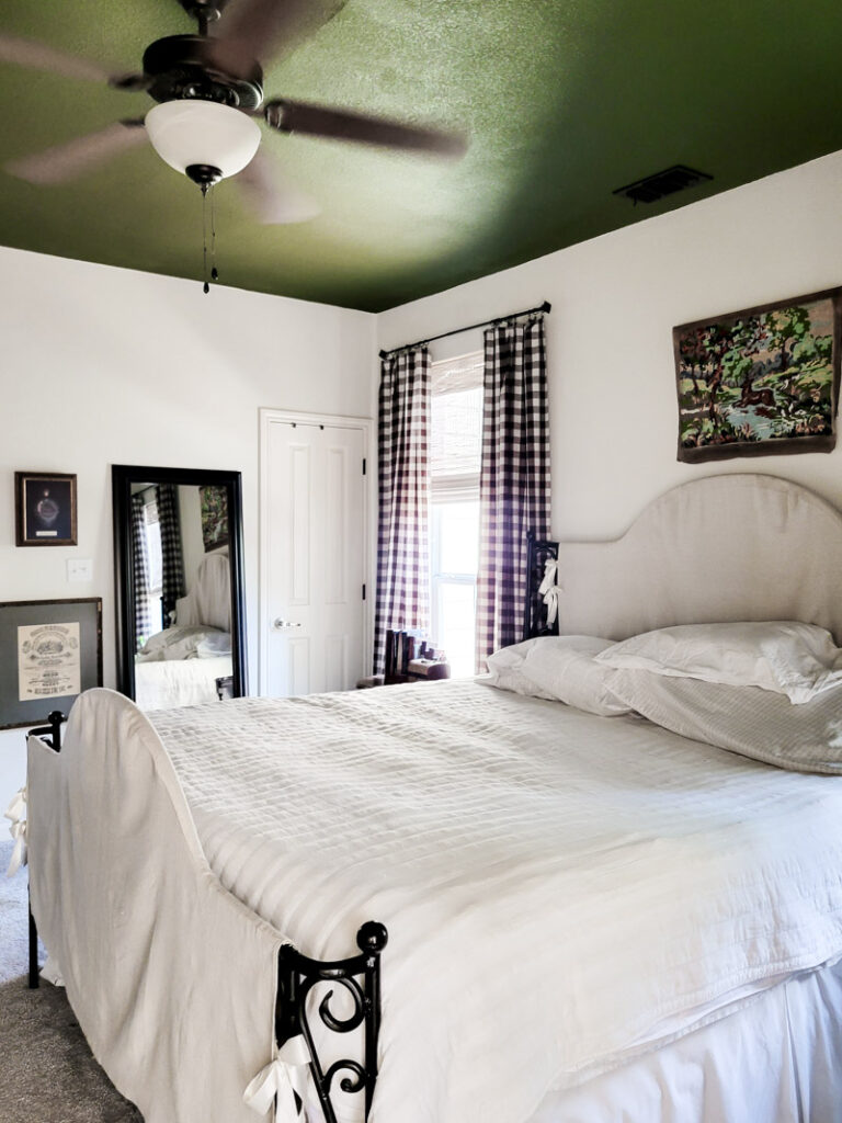 Master bedroom redo. Vintage paint color palette and budget curtain hack, get the look for less from Ballard Design. Buffalo check curtains make big impact for cheap. #greenbedroom #vintagebedroom #taxidermy #affordablecurtains