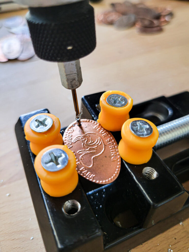 How to make a pressed penny bracelet. This DIY charm bracelet is made from inexpensive collectible souvenirs. FInd the best vacation memory in these pressed penny pieces! Then take them home amd add them to your memory keeping charm bracelet, copper is so beautiful and perfect for reliving favorite vacation spots all while looking uniquely stylish! This is an easy DIY jewelry project that has a ton of meaning. #charmbraceletDIY #pressedpennyidea #pennydisplay #souvenircollection #travelmemory