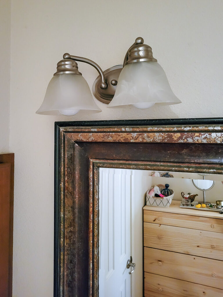 If you are looking for some budget bathroom makeover ideas you can finish in a day, these easy ideas are for you. Use what you have and give your bathroom a facelift with a small budget.One of the easiest bathroom updates is to paint light fixtures, it's such a cheap bathroom update anyone can do. #paintedlightfixture #spraypaintmakeover #budgetlighting